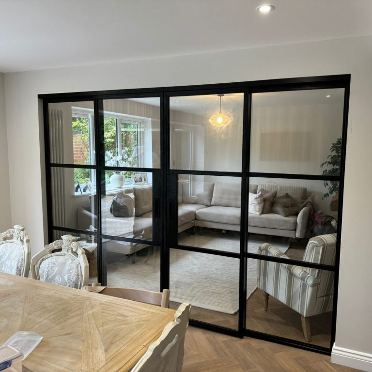 Interior view of a living room with glass partition and modern furnishings.