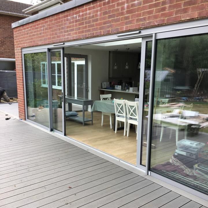 Modern glass sliding doors lead to a light-filled open-plan dining area.