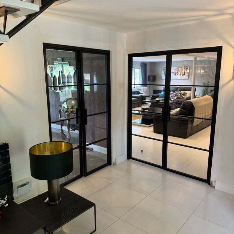 Modern interior with glass doors leading to a stylish living area.